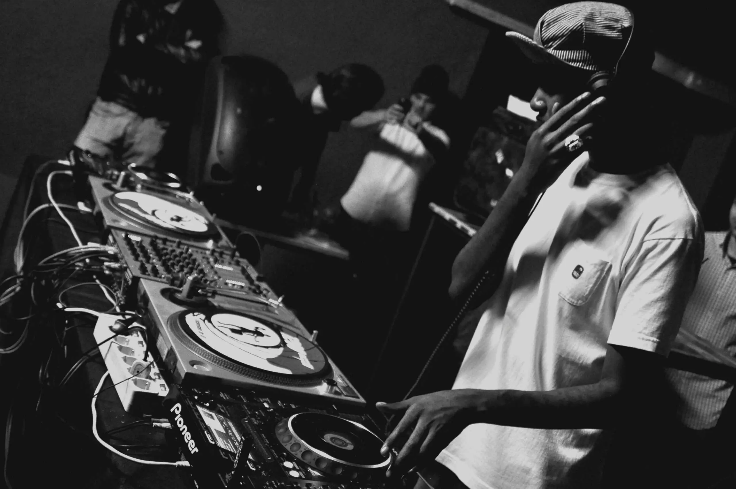 Grayscale photo of man playing dj mixing console